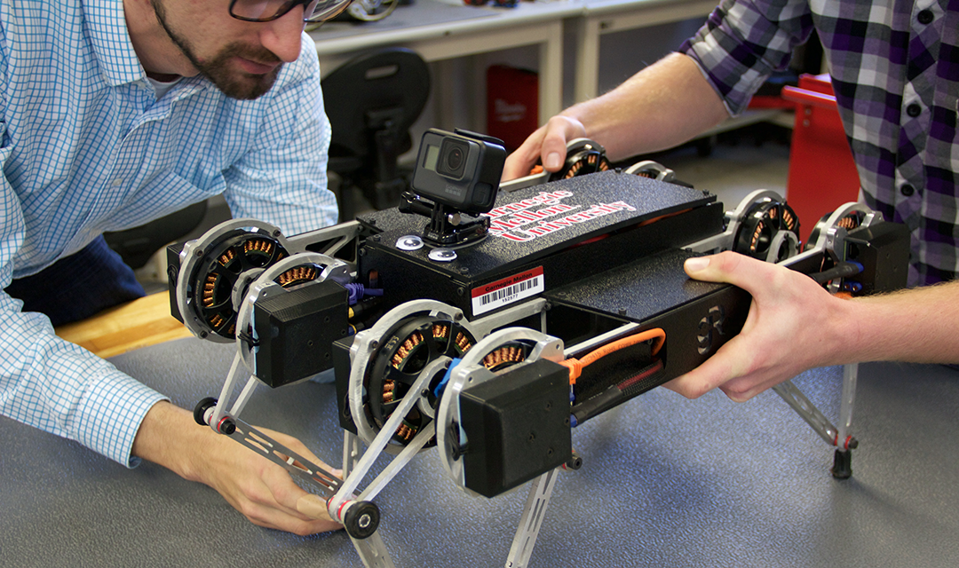 Professor Aaron Johnson working on a four-legged square robot